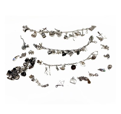 Lot 268 - A large collection of silver charms on three bracelets and loose.