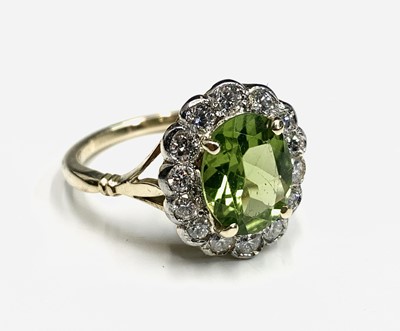 Lot 502 - A peridot and diamond oval cluster ring....