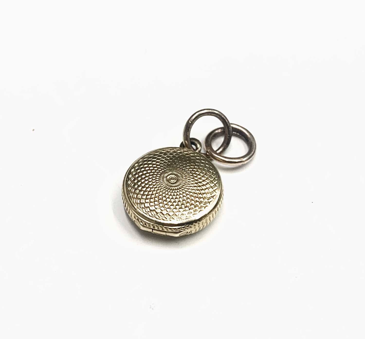 Lot 556 - A Victorian tiny gold locket with swirl