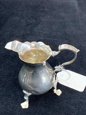 Lot 59 - A Georgian silver bellied crested cream jug...