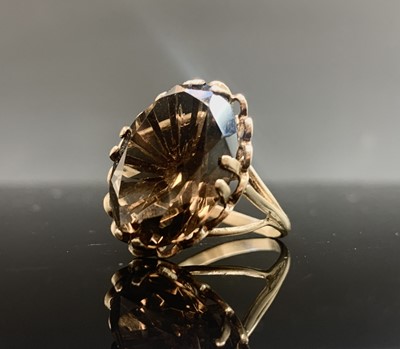 Lot 679 - A gold ring set with a large faceted smoky...