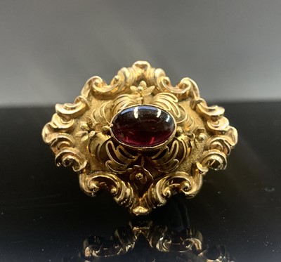 Lot 528 - A Victorian carbuncle brooch set ornately in...