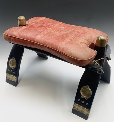 Lot 44 - A black painted and brass folding camel stool,...