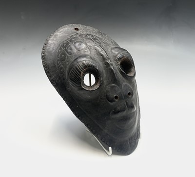 Lot 64 - A painted wall hanging tribal mask, with...