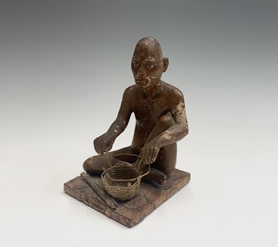 Lot 1050 - A Indian brown painted figure of a basket...