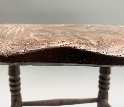 Lot 71 - An elm stool, 19th century, the dished seat on...