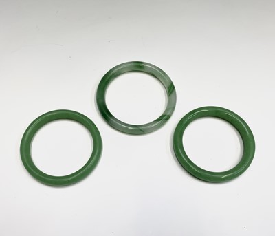 Lot 166 - Three Chinese jade bangles, diameter 8cm, 7cm...