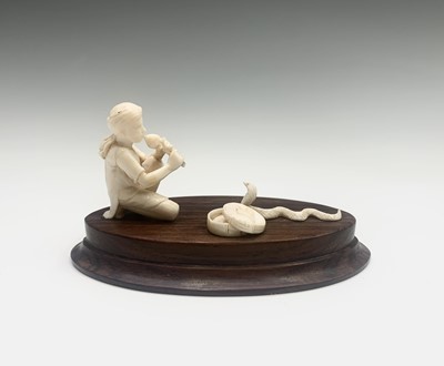 Lot 1067 - An Indian ivory model of a snake charmer,...