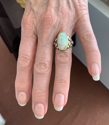 Lot 417 - An 18ct gold ring set an opal flanked by three...