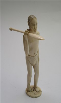 Lot 85 - An African ivory figure of a man holding a...