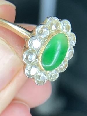 Lot 18 - A cabochon emerald and diamond oval cluster...