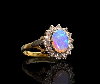 Lot 58 - An opal and diamond oval cluster ring 3.7gm