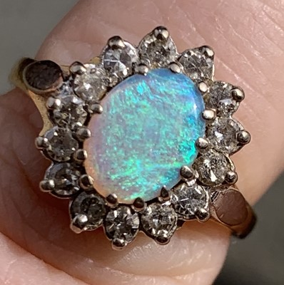 Lot 58 - An opal and diamond oval cluster ring 3.7gm