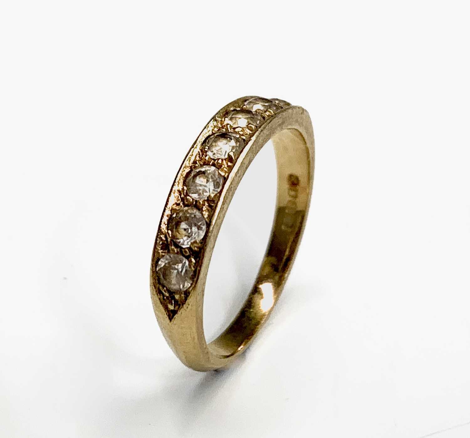 Lot 124 - An 18ct gold ring set a line of seven diamonds...