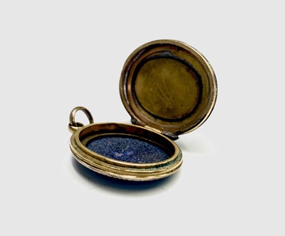 Lot 319 - An engraved gold locket with a cross on blue...