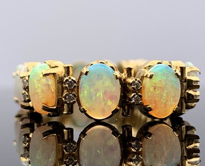 Lot 10 - An 18 ct gold bracelet with twenty opals, each...