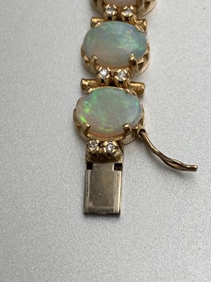 Lot 10 - An 18 ct gold bracelet with twenty opals, each...