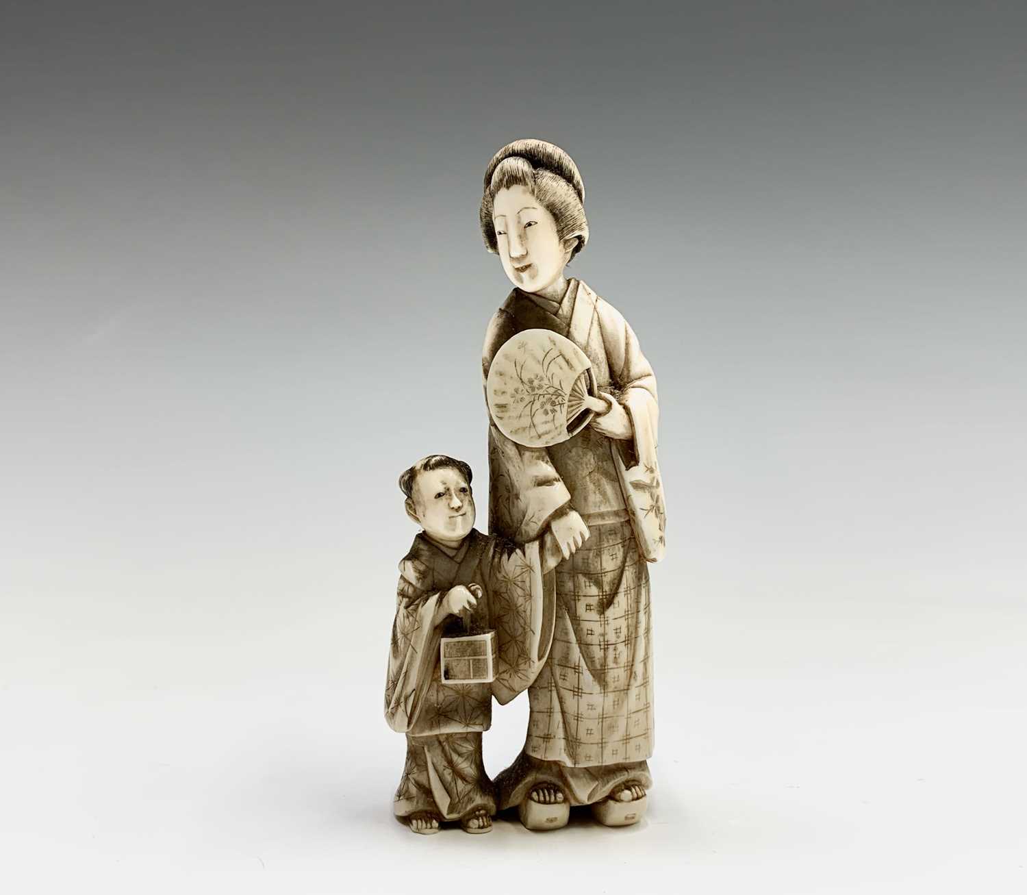 Lot 20 - A Chinese carved ivory group of a mother and...