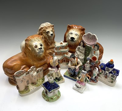 Lot 1083 - Three similar Staffordshire figures of lions,...