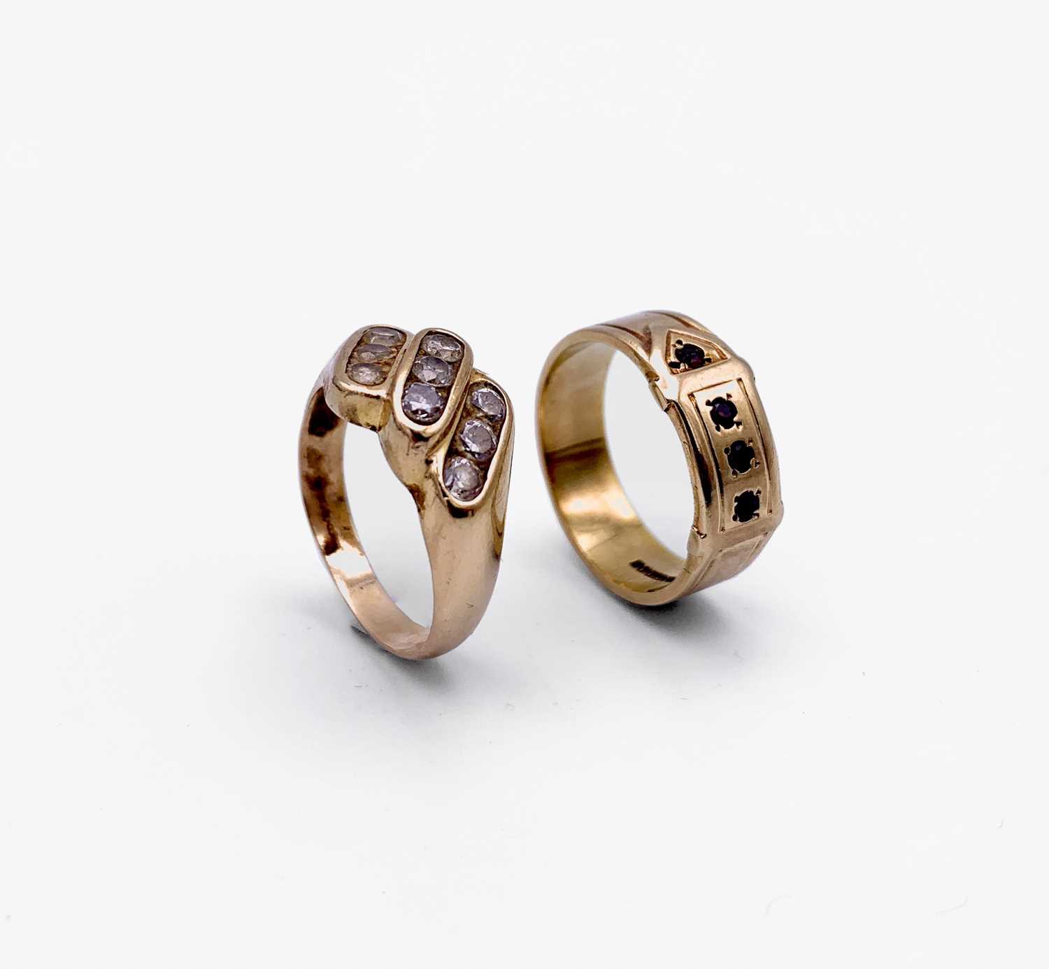 Lot 130 - A 9ct gold buckle ring set with red stones and...
