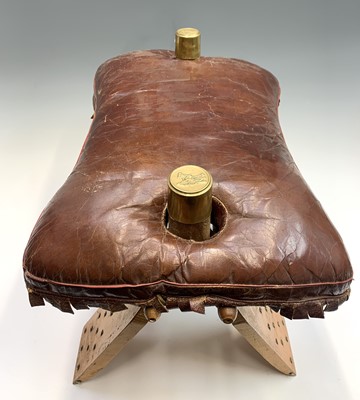 Lot 3290 - A leather topped camel saddle style footstool....