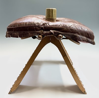 Lot 3290 - A leather topped camel saddle style footstool....