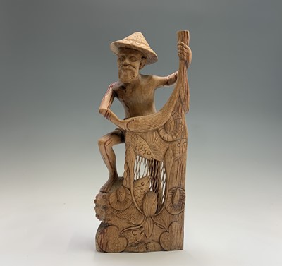 Lot 486 - An Eastern carved wood figure of a fisherman...