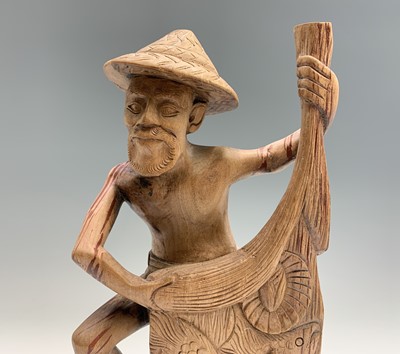 Lot 486 - An Eastern carved wood figure of a fisherman...
