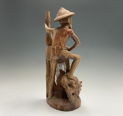 Lot 486 - An Eastern carved wood figure of a fisherman...