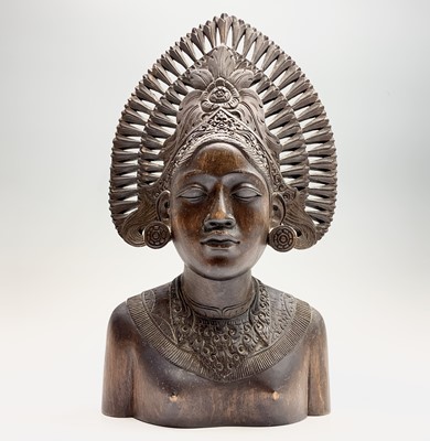 Lot 493 - A Balinese carved wood bust of a woman wearing...