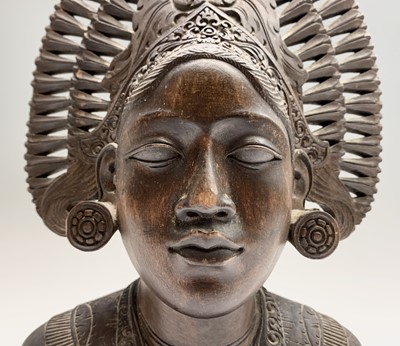 Lot 493 - A Balinese carved wood bust of a woman wearing...