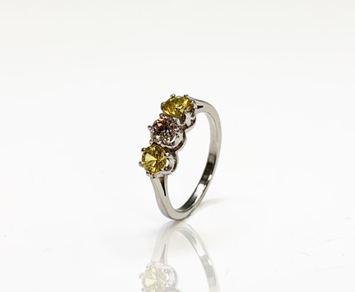 Lot 51 - A platinum three stone ring with a central...