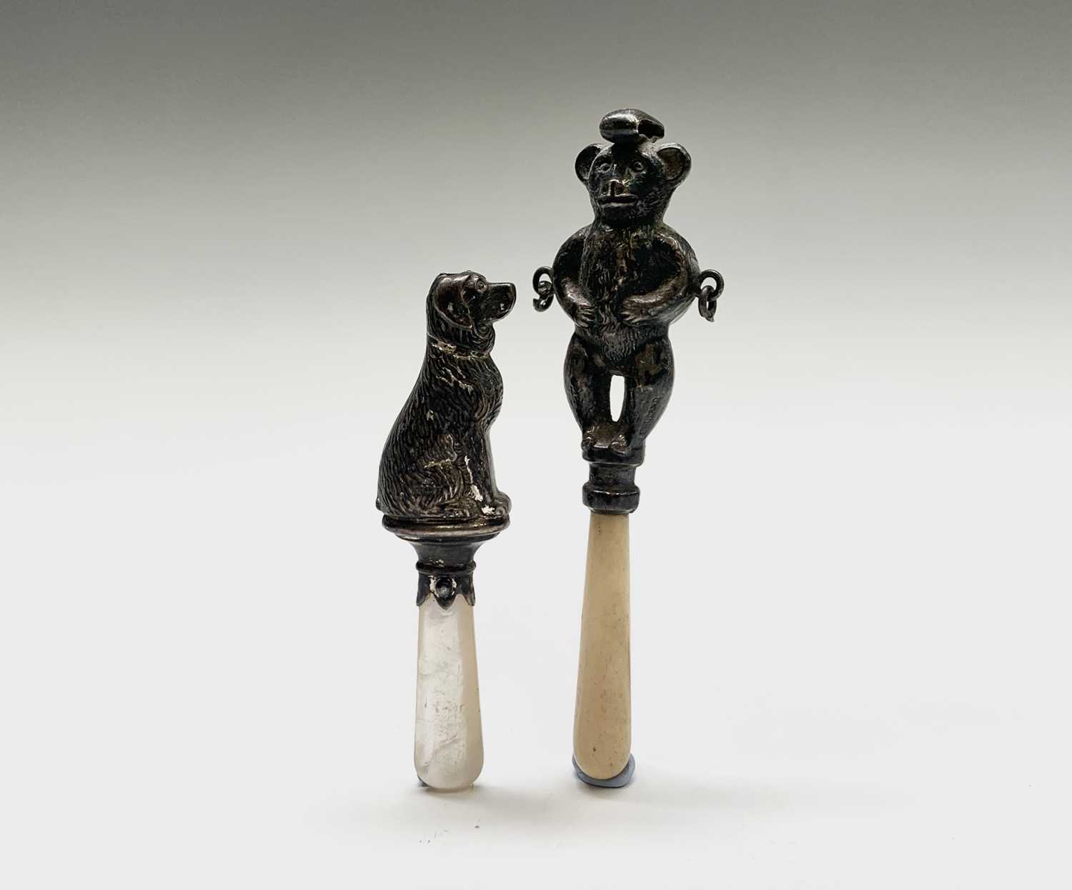 Lot 1052 - Two silver rattles, one a teddy bear the other...