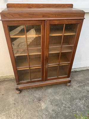 Lot 3180 - An Arts and Crafts oak bookcase, with a pair...