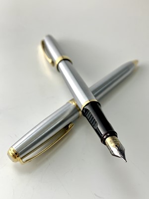 Lot 1168 - A Sheaffer brushed chrome, gold trim fountain...