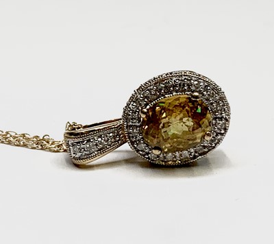 Lot 104 - A yellow sapphire (2.7cts) and diamond pendant...