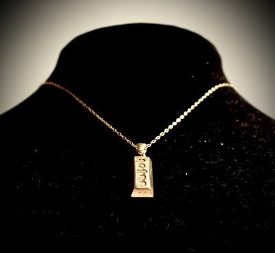 Lot 250 - A 9ct gold ingot pendant and chain with...