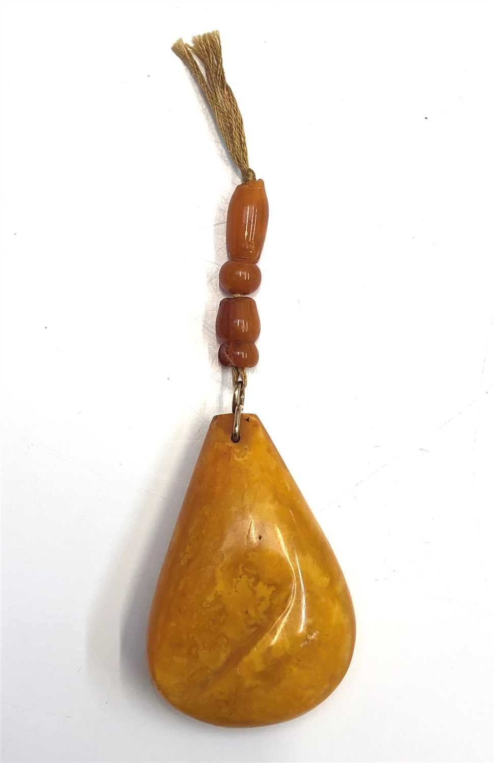 Lot 2468 - An amber pear shaped pendant with