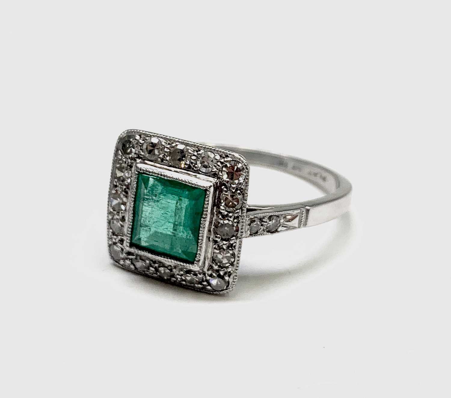 Lot 53 - A platinum emerald and diamond square ring 4.2gm