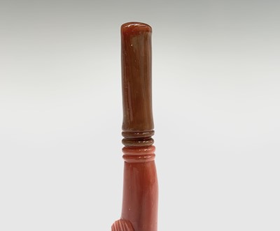 Lot 30 - A gold cheroot holder in the mouth of a red...