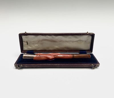 Lot 30 - A gold cheroot holder in the mouth of a red...