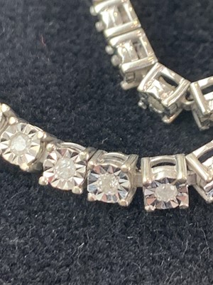 Lot 332 - A 9ct white gold line bracelet set with...