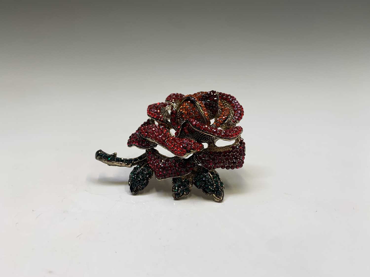 Lot 186 - A costume jewellery, red rose crystal brooch...