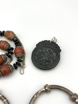 Lot 177 - A Chinese black stone carved pendant 40mm wide,...