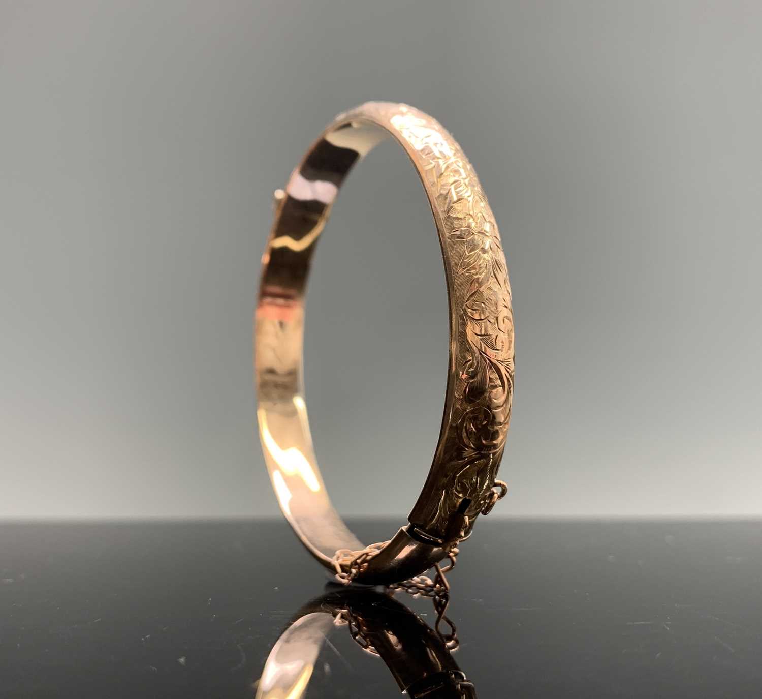 Lot 235 - A chased 9ct gold hinged bangle 9.4gm