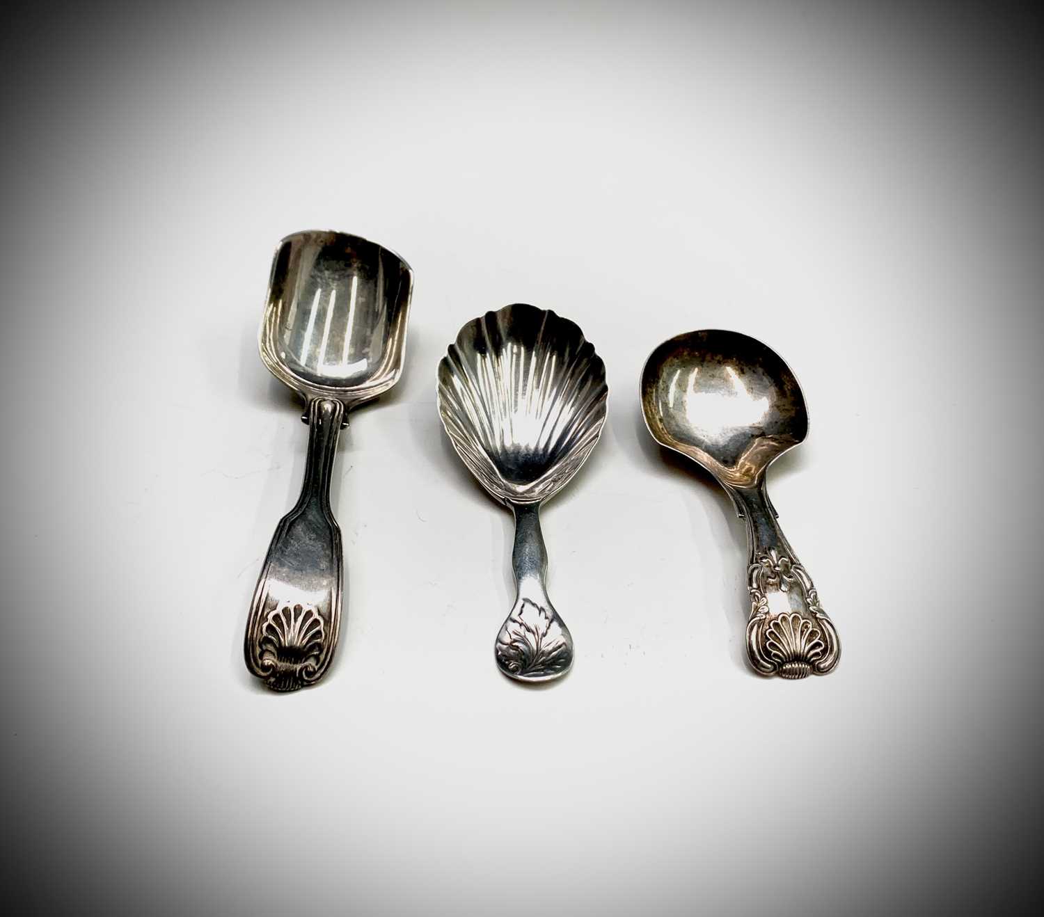 Lot 1044 - Three Victorian silver caddy spoons: Henry...