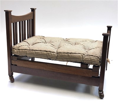 Lot 171 - An Edwardian mahogany doll's bed with calico...