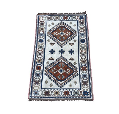 Lot 1249 - A Turkish rug, the ivory field with two...