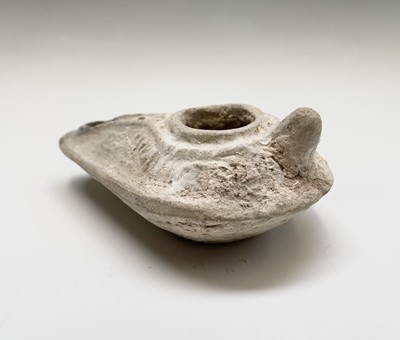 Lot 134 - A Roman terracotta oil lamp, with moulded...