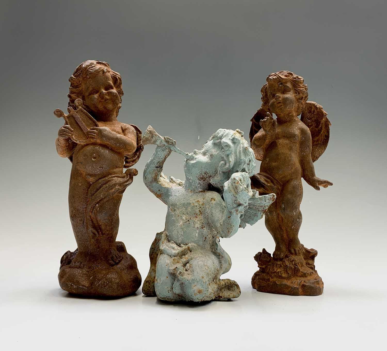 Lot 135 - Three cast iron cherubs, one painted blue, the...